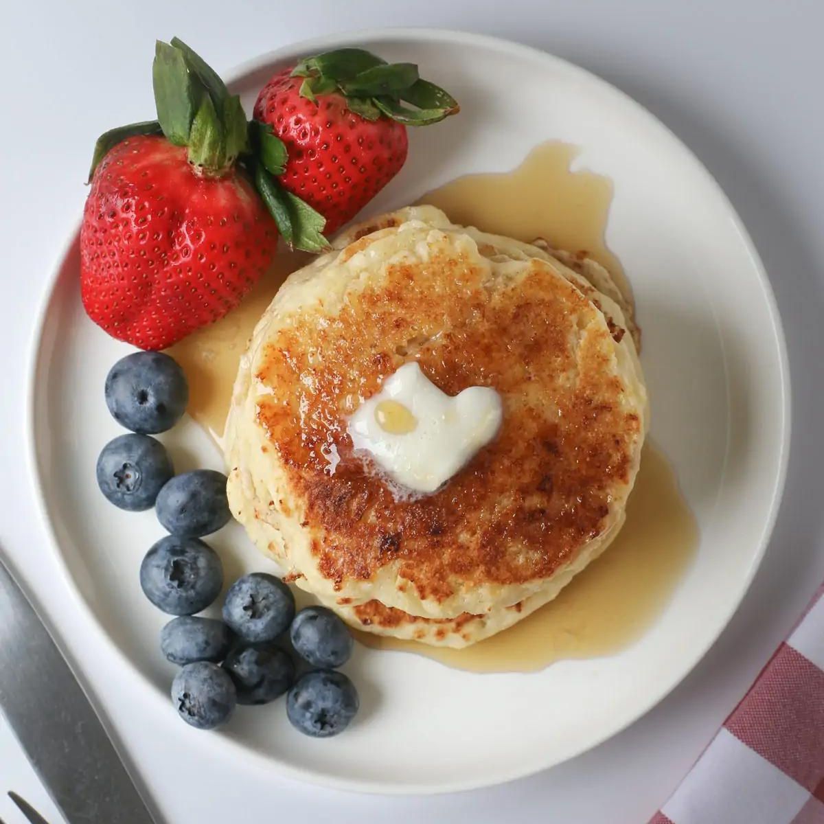 Overhead shot of pancake stack with heart shaped butter pat.