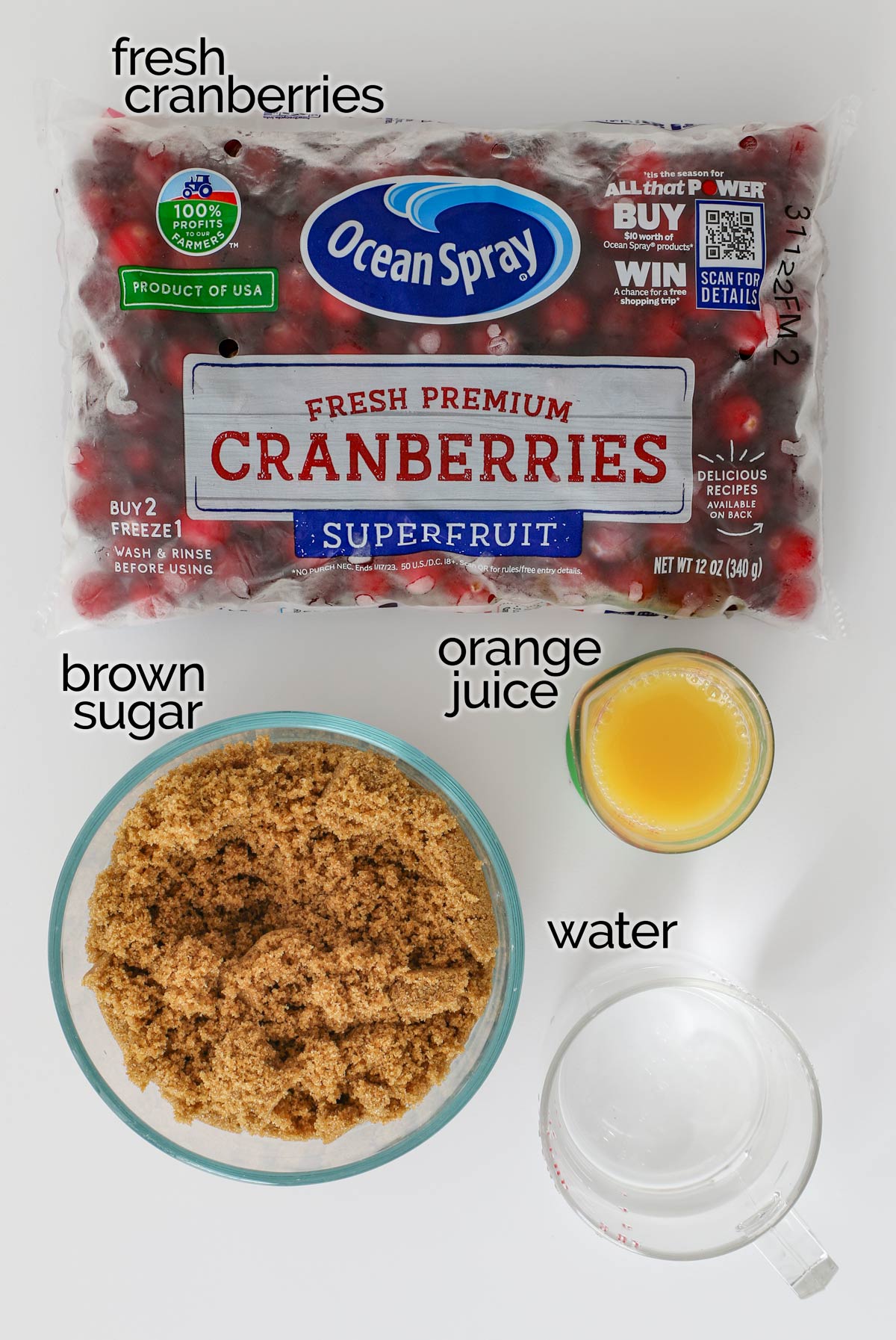 ingredients for cranberry sauce, laid out on a white counter.