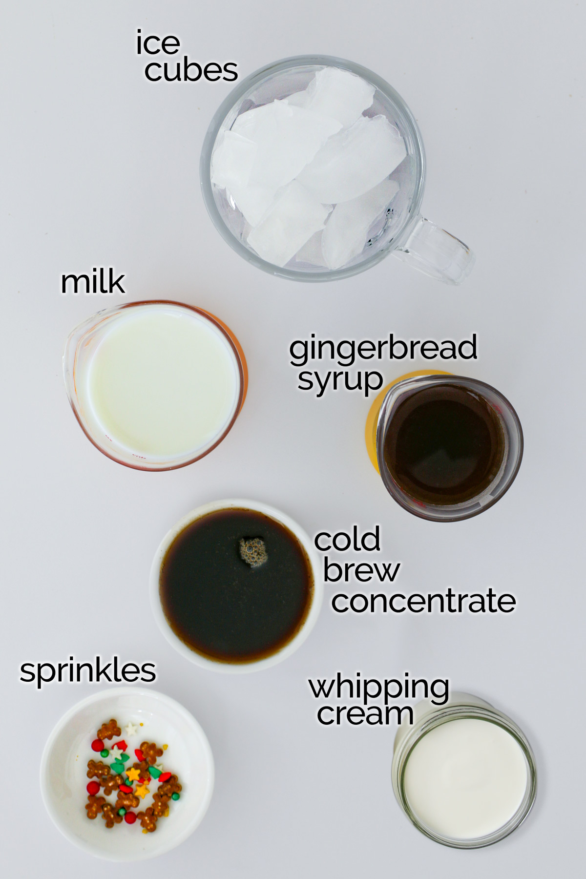ingredients to make a gingerbread latte laid out on white counter.