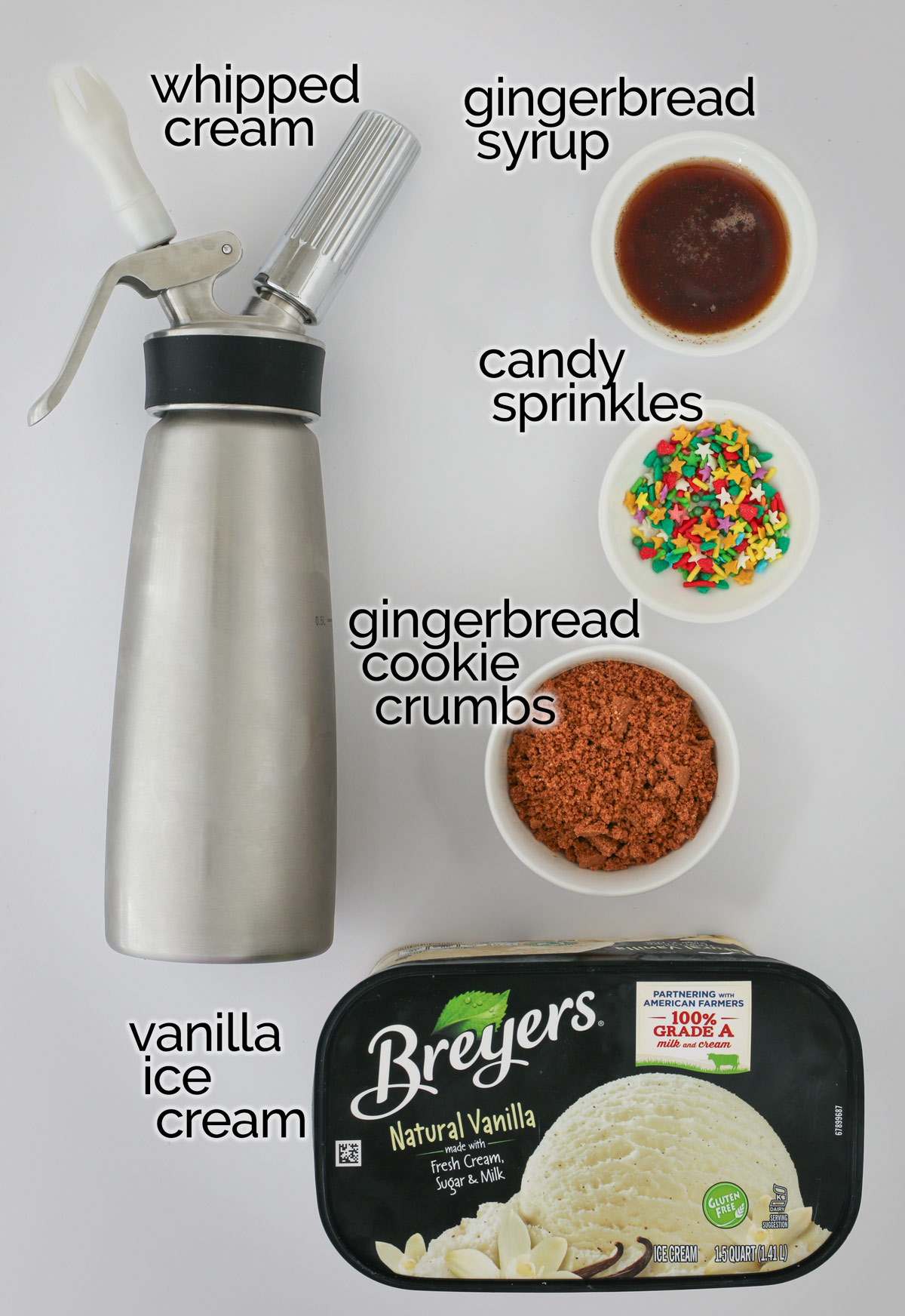ingredients to make gingerbread ice cream sundaes laid out on white counter.