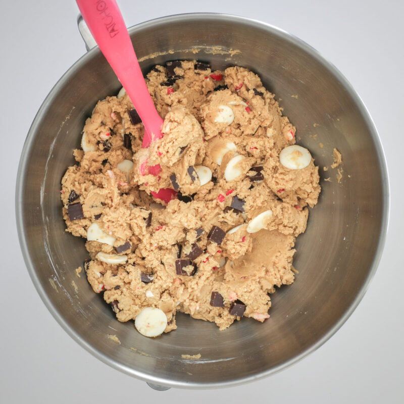 the peppermint chocolate chip cookie dough in a mixing bowl with a red spatula.