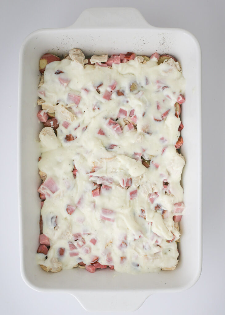white sauce spread over the meat and potatoes in the baking dish.