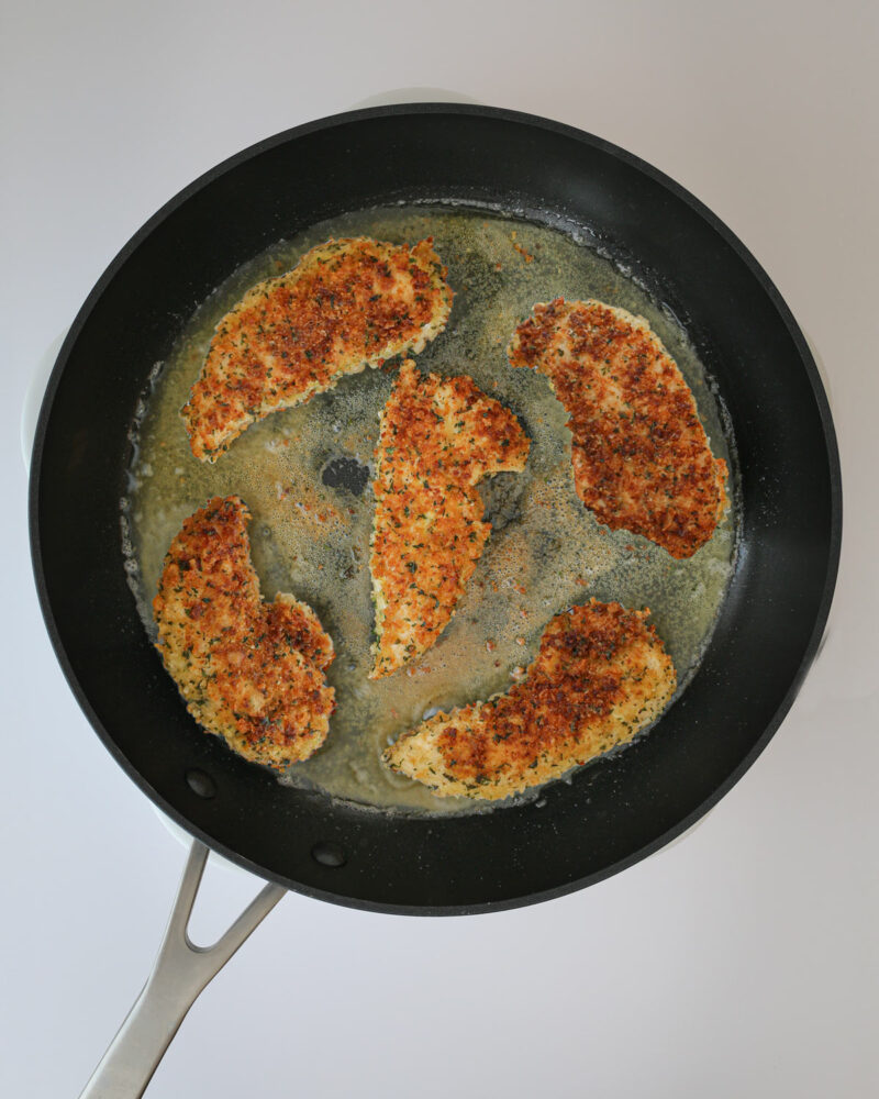 fried chicken strips in frying pan.