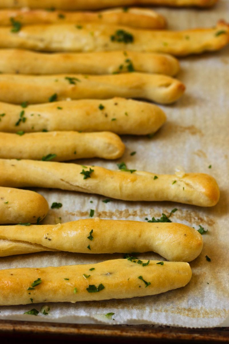 garlic bread sticks on parchment lined baking sheet.