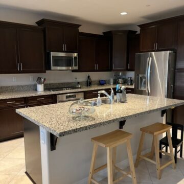 clean and pristine kitchen with a cake stand of cookies on counter.