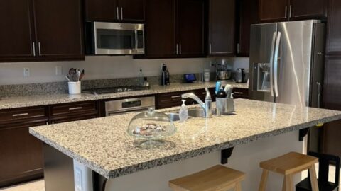 clean and pristine kitchen with a cake stand of cookies on counter.