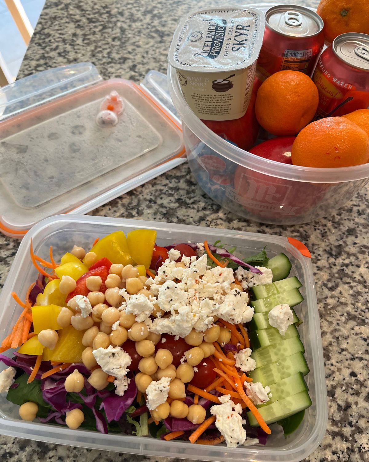 meal prep salad next to a tub of other lunch items to pack.