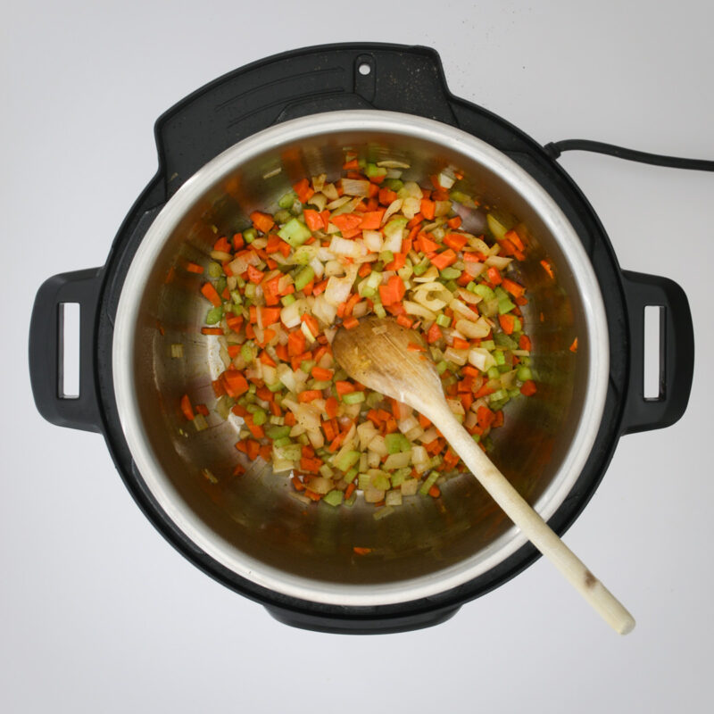 mirepoix cooked in instant pot with a wooden spoon.
