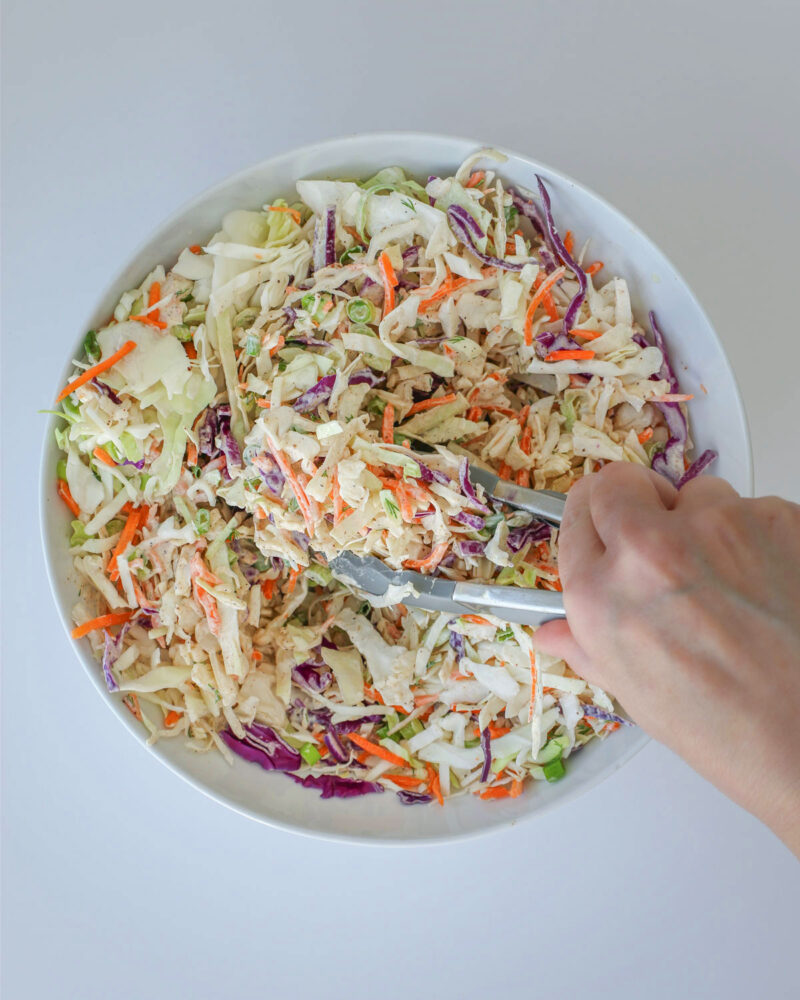 mixing together the coleslaw.