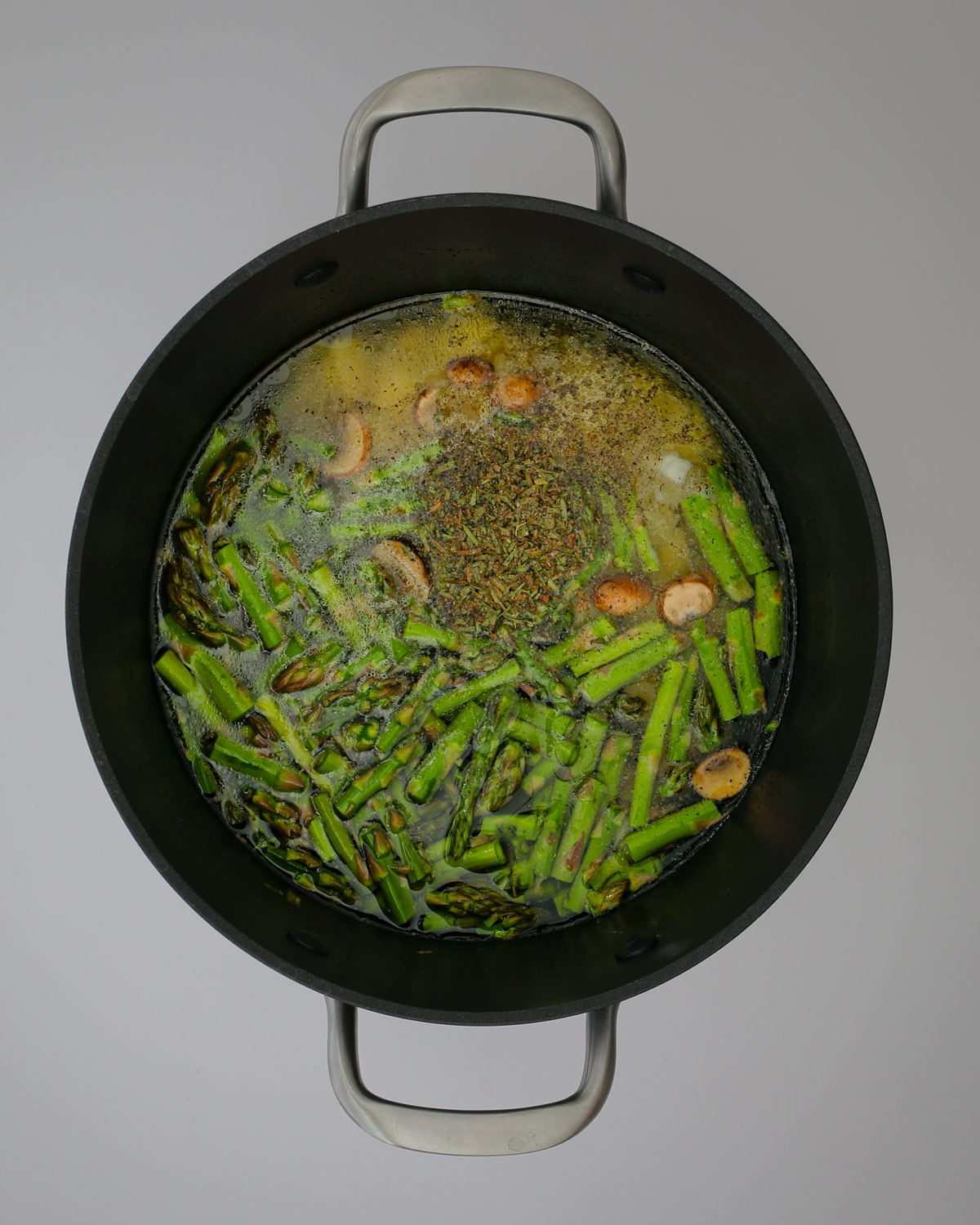 potatoes, asparagus, water, and spices added to the pot.