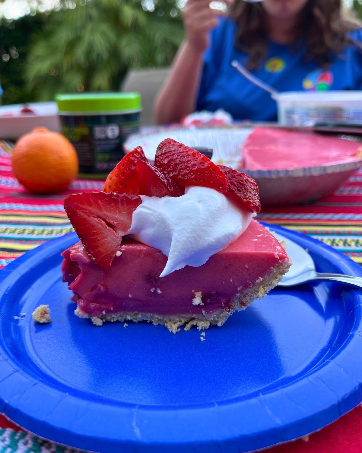 strawberry jello pie on blue paper plate.