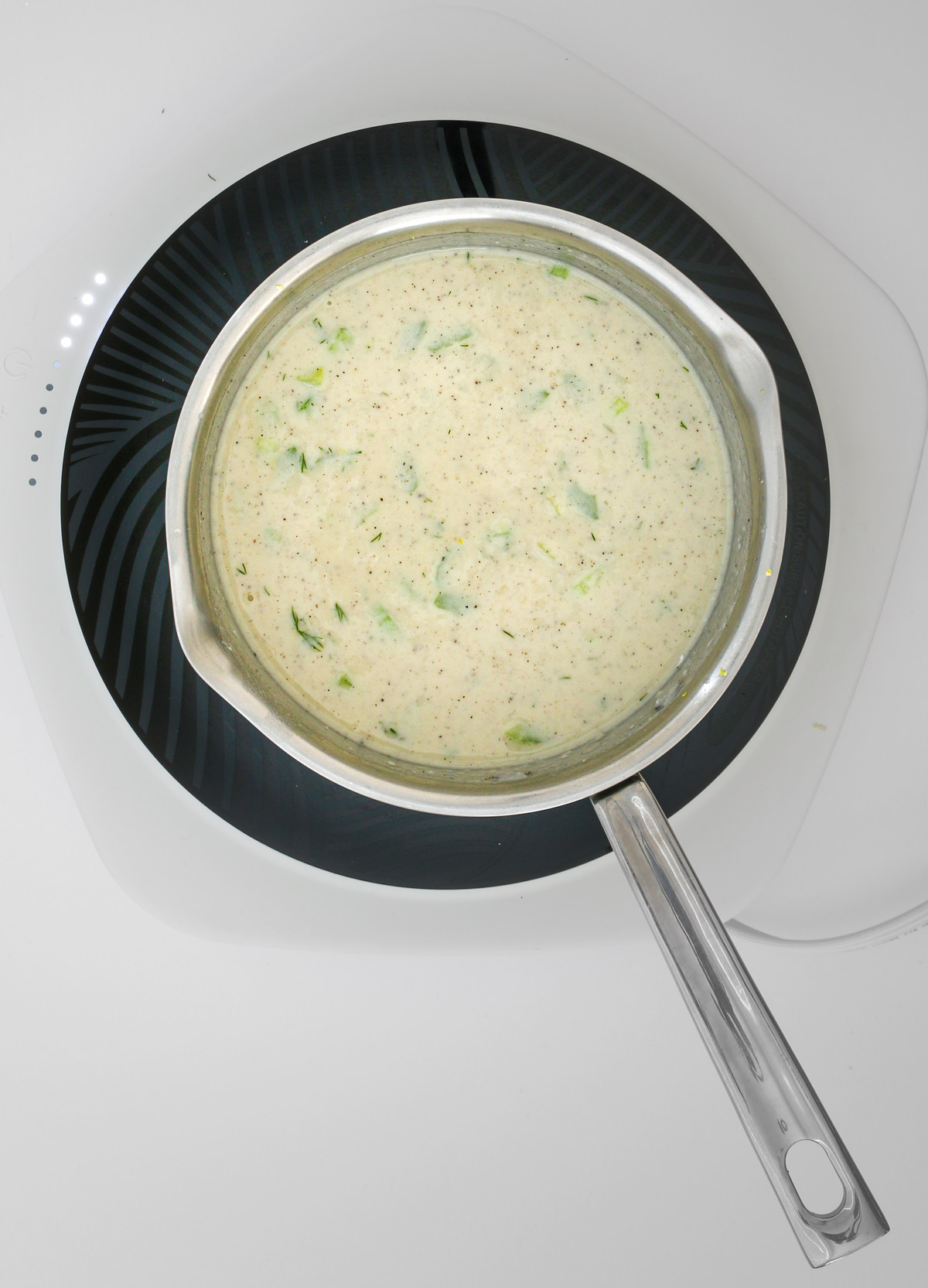 the white sauce simmering in the sauce pan.