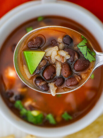 spoonful of bean and rice soup over a bowl.