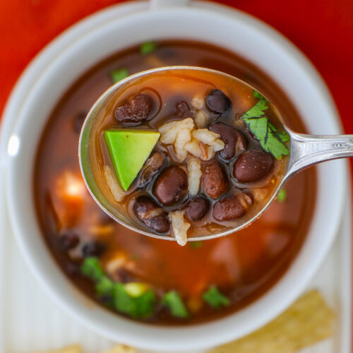 spoonful of bean and rice soup over a bowl.