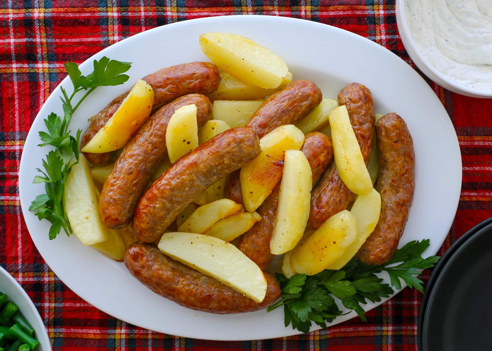 platter of sausage and potatoes with parsley garnish.