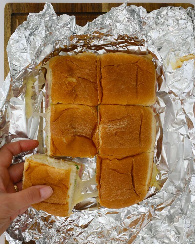 baked sandwiches with hand pulling one out.