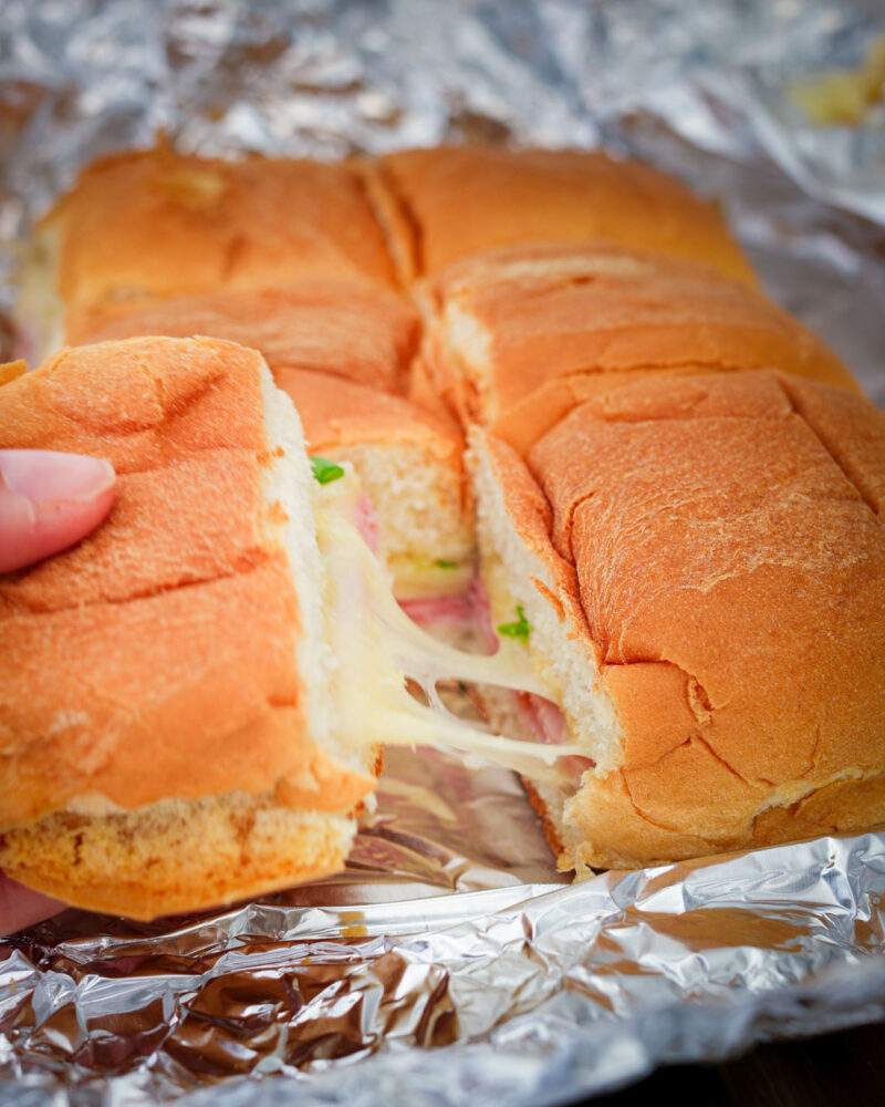 side view of pulling out a sandwich with melted cheese.