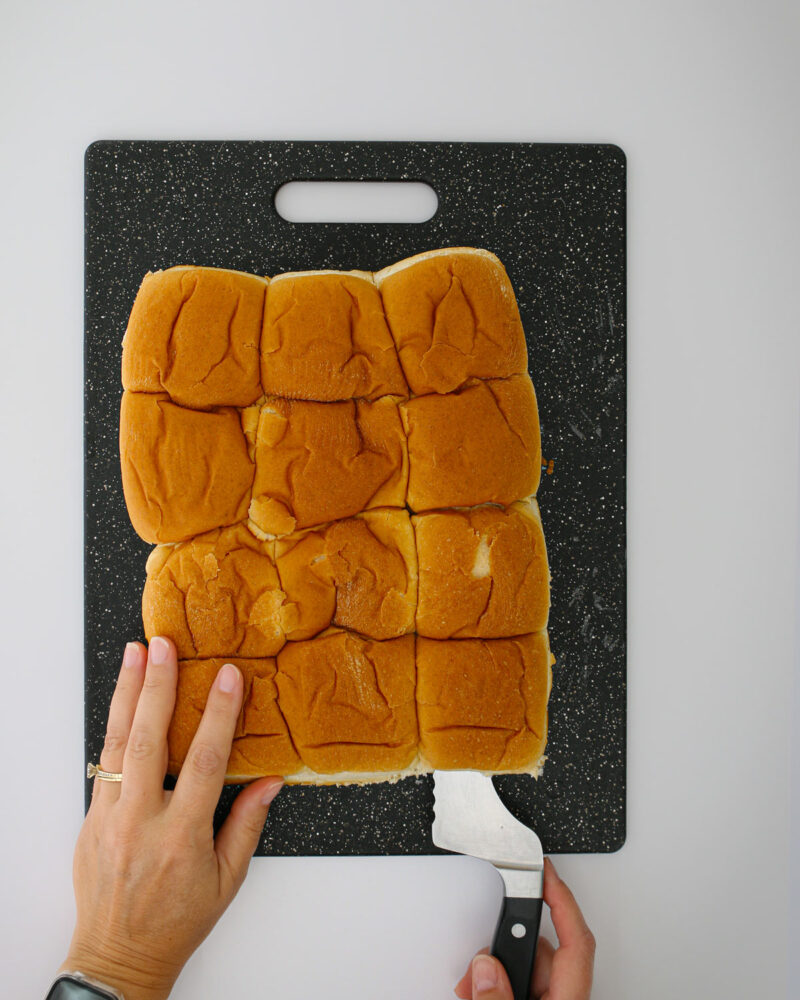 slicing the sliders apart with a large bread knife.