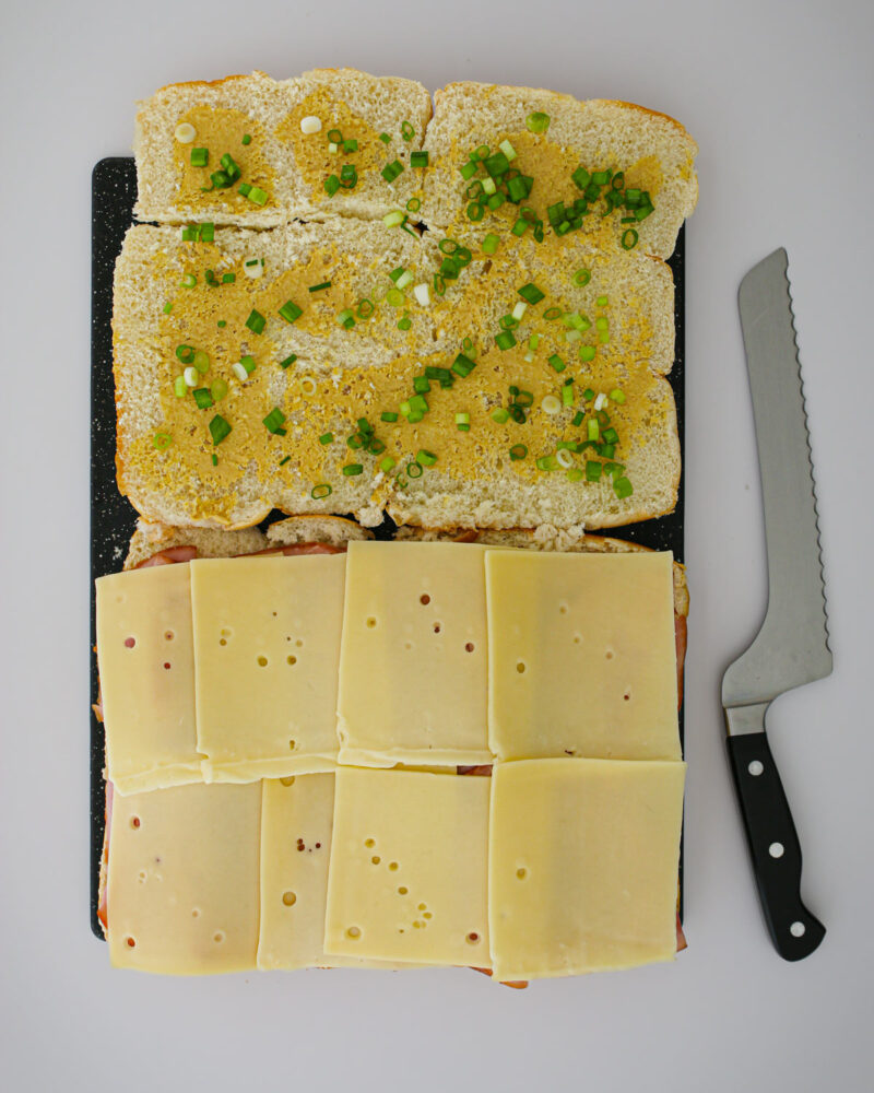 mustard and green onions spread on the tops of the sandwiches. 