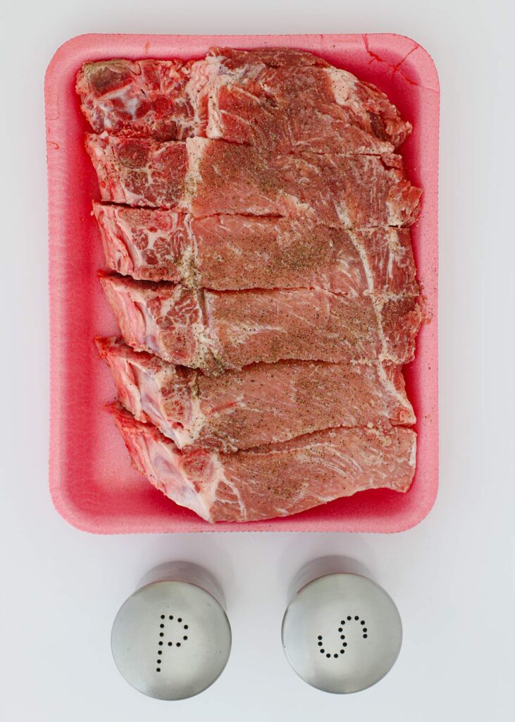 seasoning pork strips with salt and pepper.