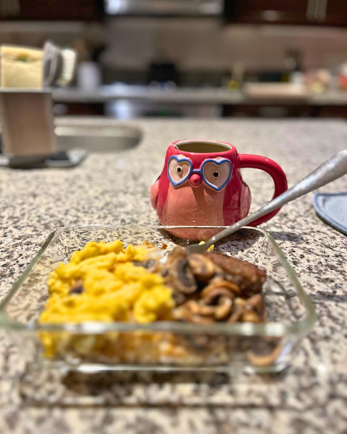 reheated eggs with owl mug on kitchen island.