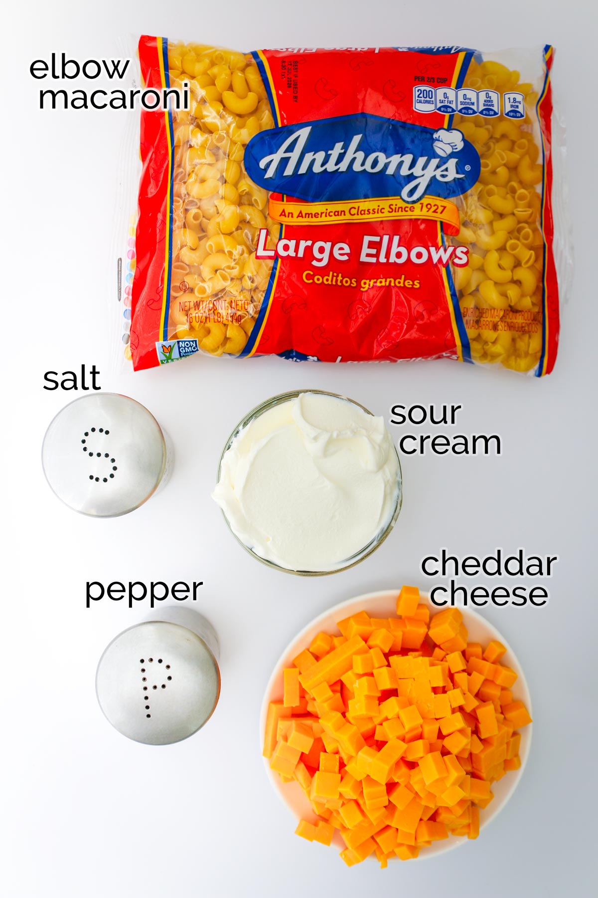 ingredients to make Mac and cheese laid out on white surface.