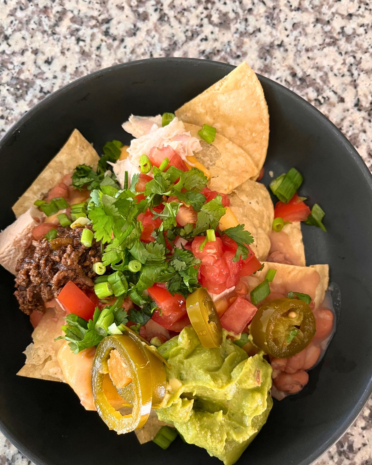 nachos in a black bowl.