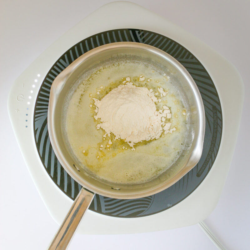 adding flour to melted butter in saucepan.