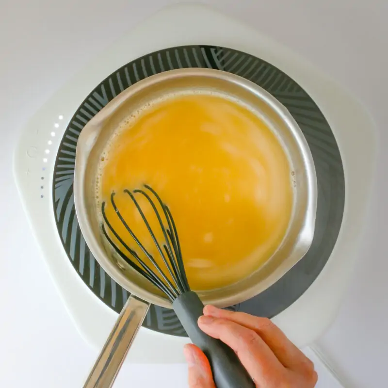 whisking broth into roux to make an easy gravy.
