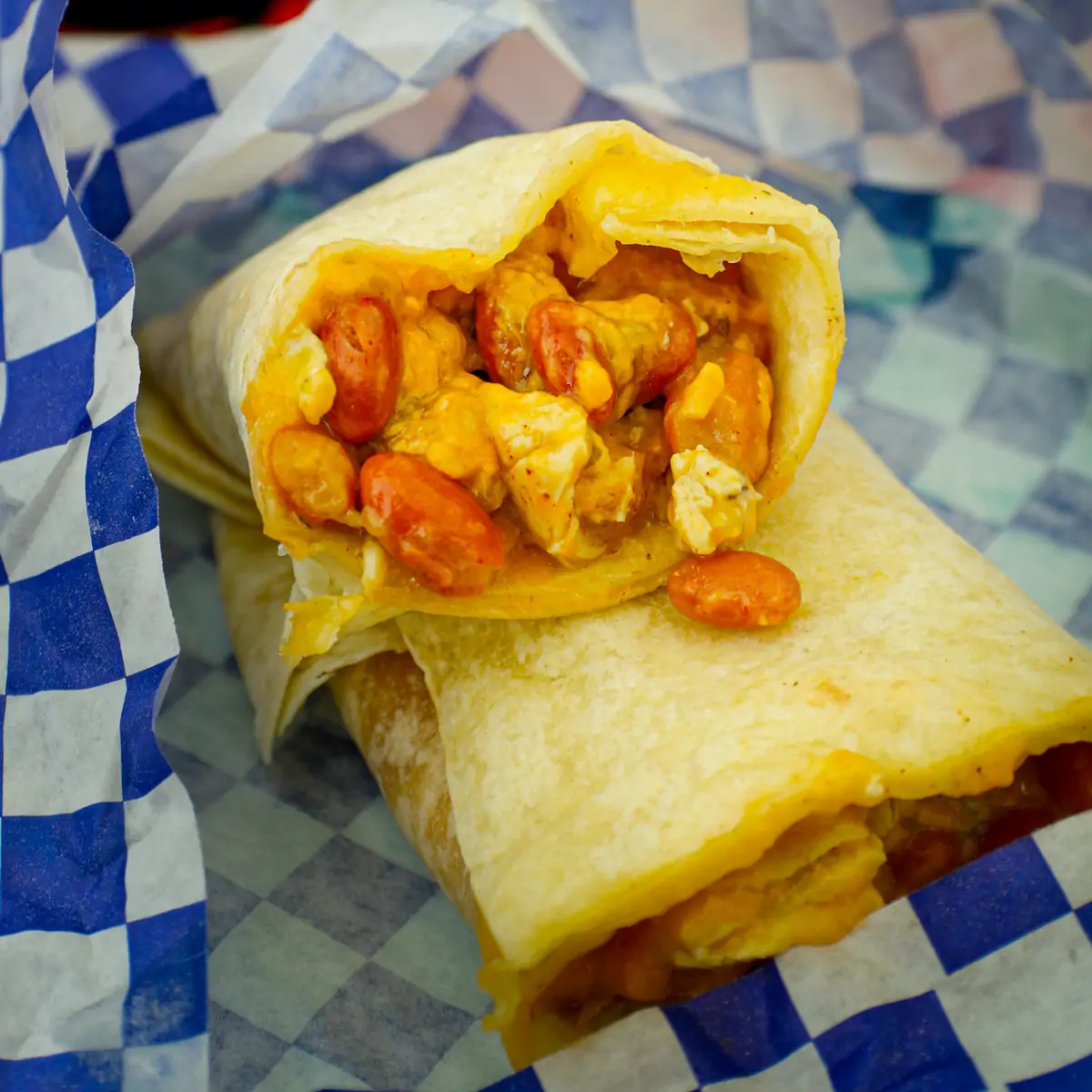 close up of freezer burrito cut in half in paper-lined basket.