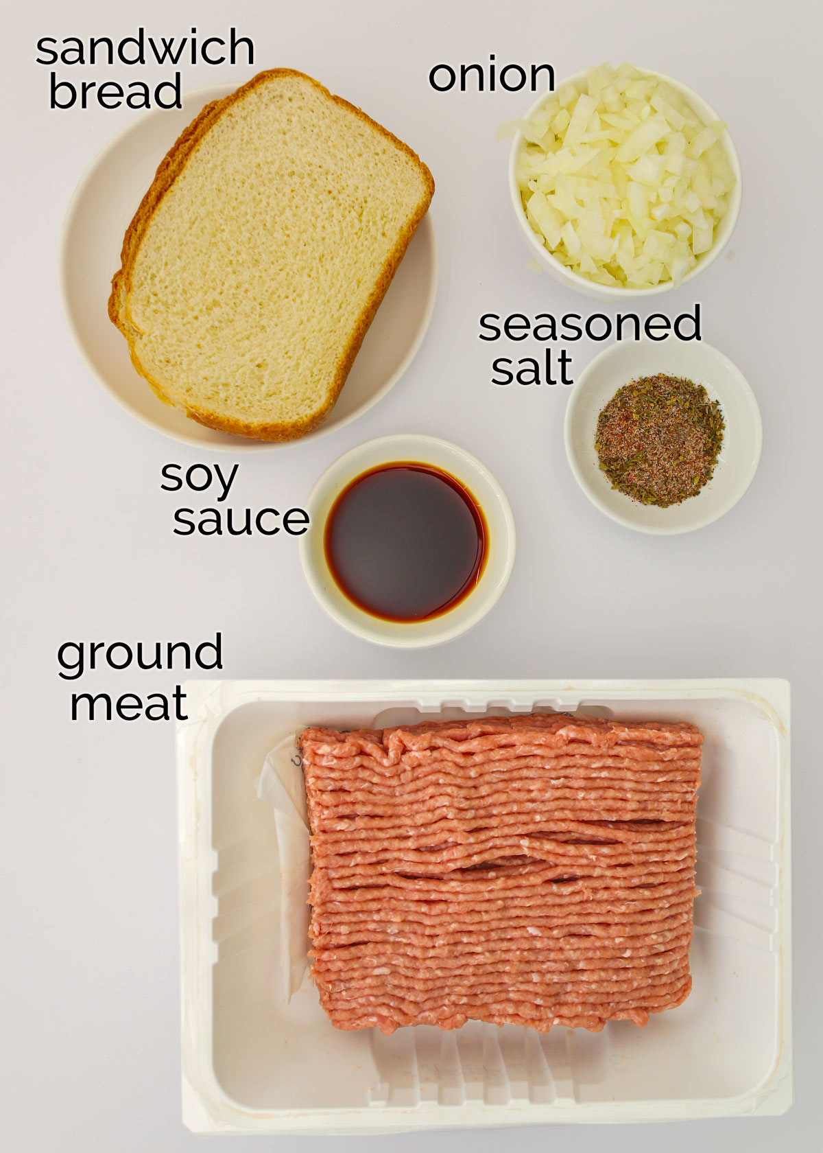 ingredients for mini meatloaves laid out on white countertop.