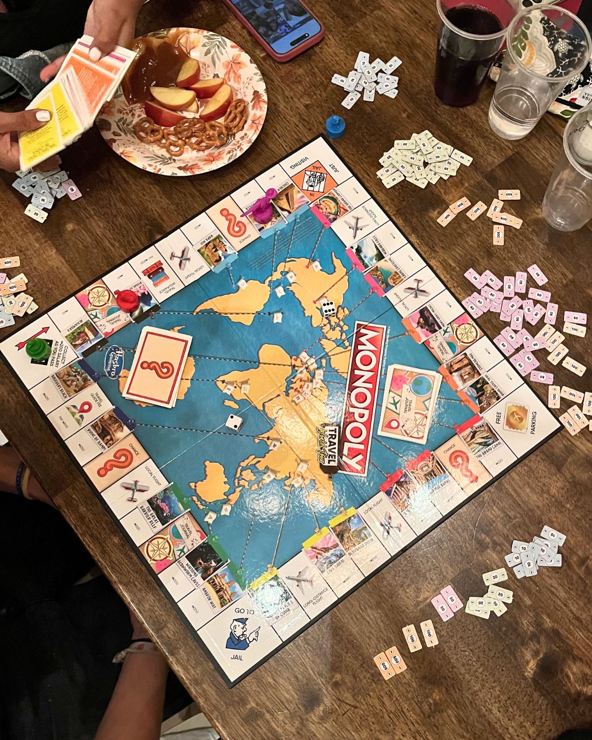 overhead shot of monopoly travel with plates of food.