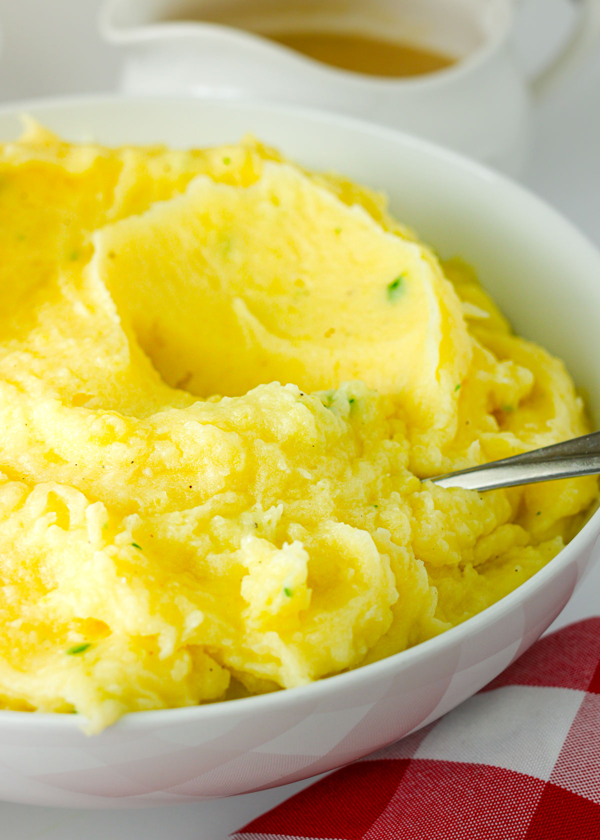 creamy mashed potatoes in a big bowl with a spoon.