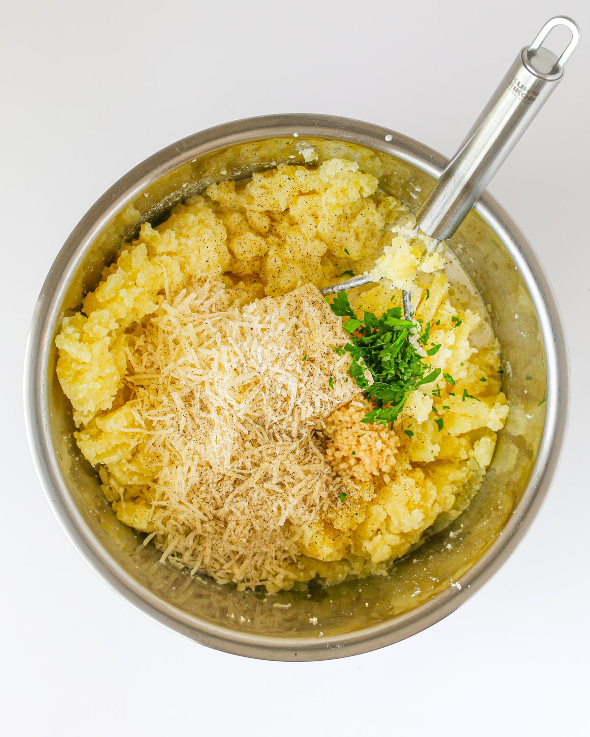 adding the mix-in's to flavor alfredo mashed potatoes.