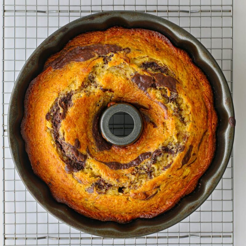 the baked cake in a pan on a rack.
