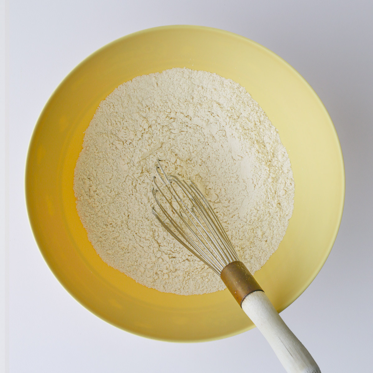 dry ingredients whisked together in yellow bowl.