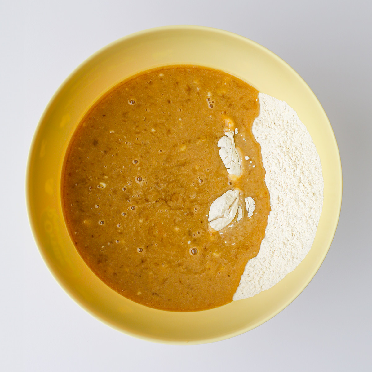 wet ingredients added to the dry in the yellow bowl.