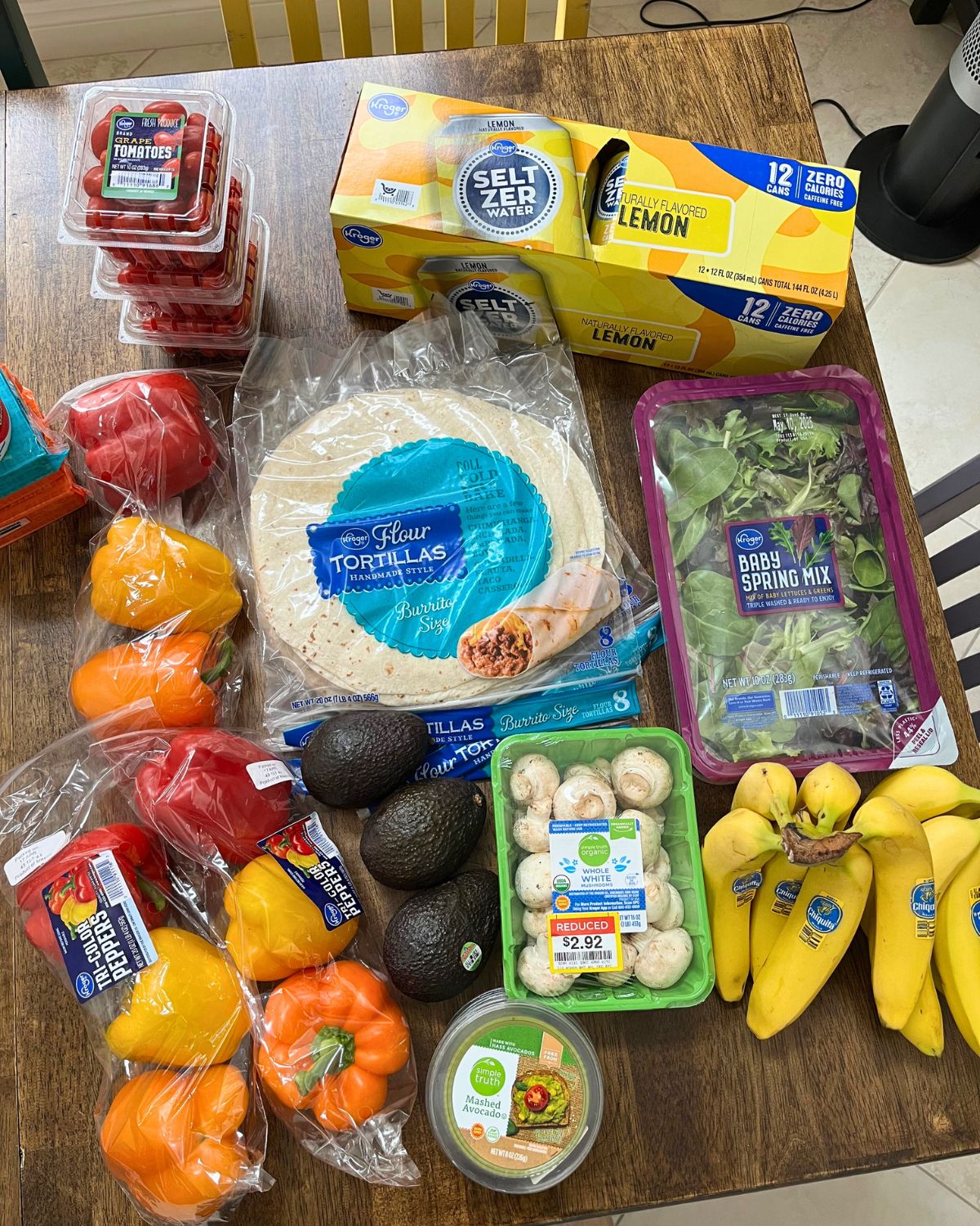 produce, water, and tortillas laid out on table.