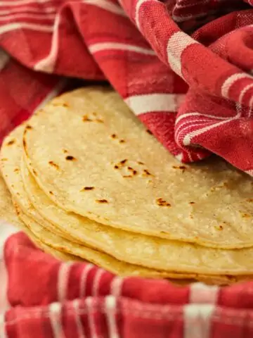 warmed tortillas wrapped in a red towel.