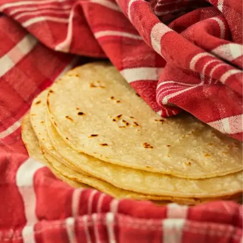 warmed tortillas wrapped in a red towel.