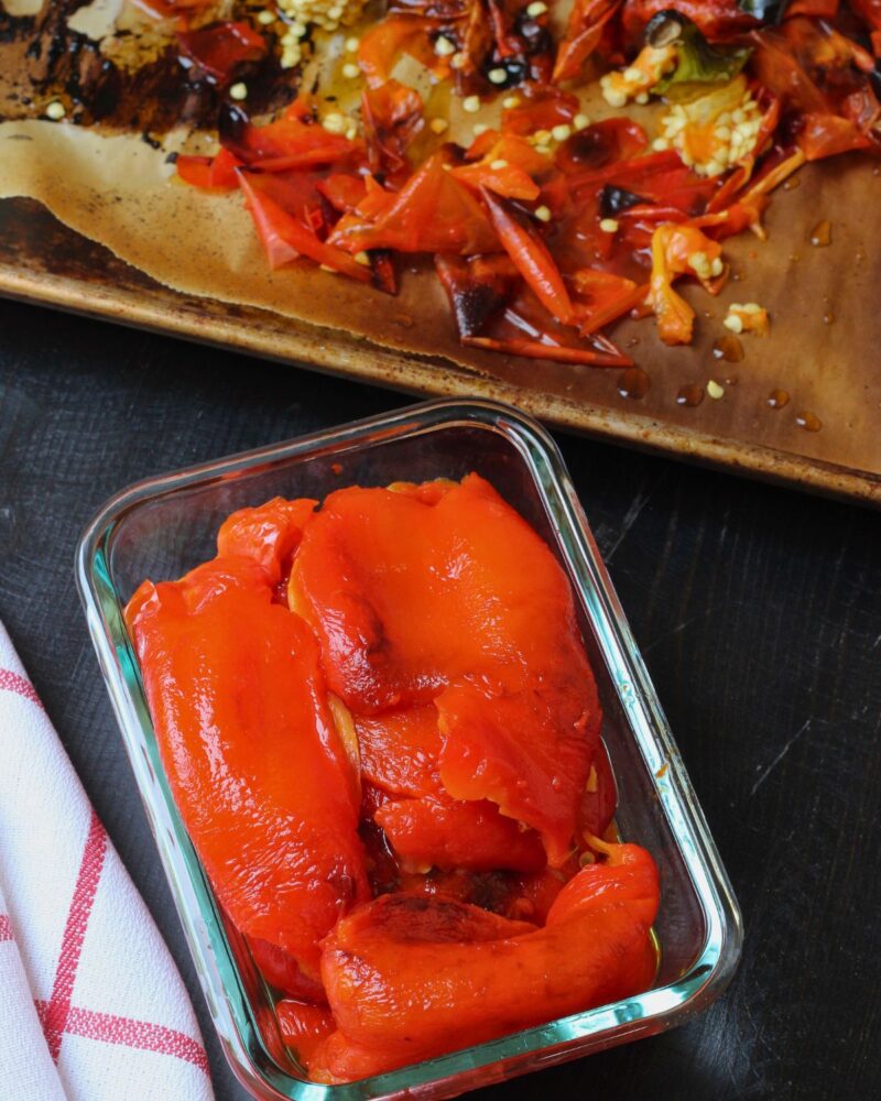 pepper peels on tray with peeled peppers in glass dish.