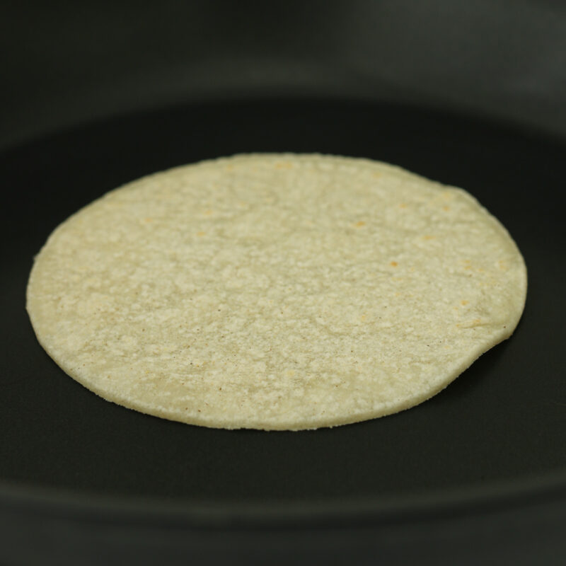 corn tortilla on griddle.