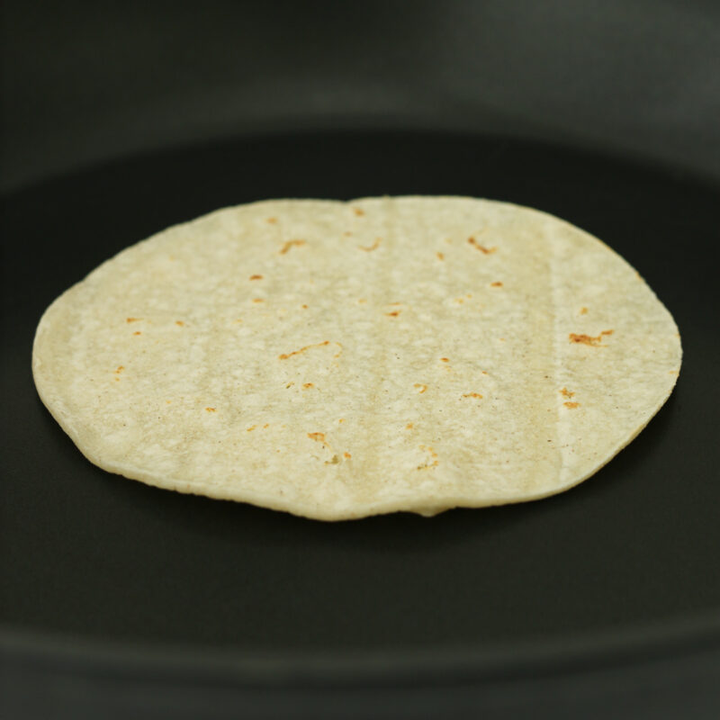 flipped tortilla warming on griddle.