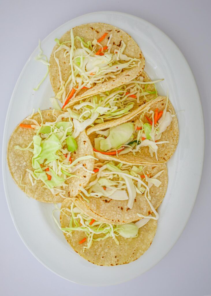 platter of tortillas topped with cabbage.