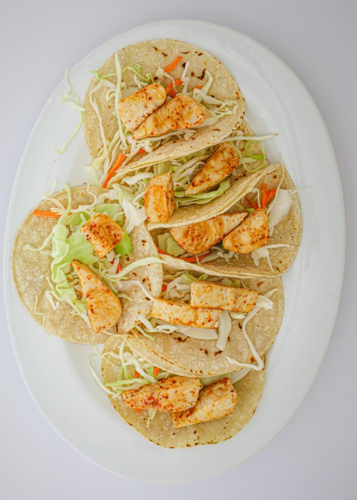 layer of fish chunks atop the cabbage in tortillas.