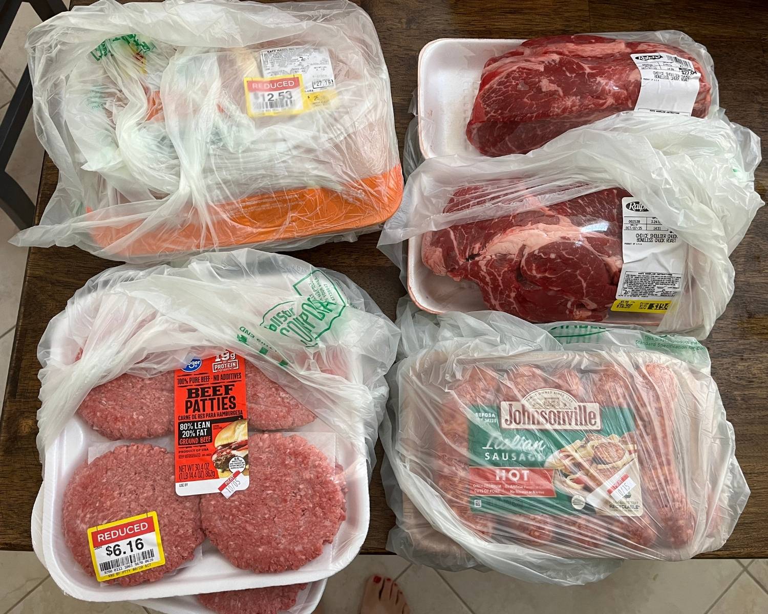 sale meat on table, wrapped in plastic bags.
