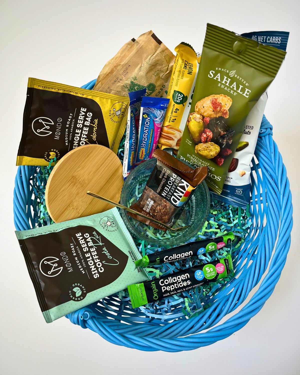 blue basket filled with coffee packets and other breakfast items.