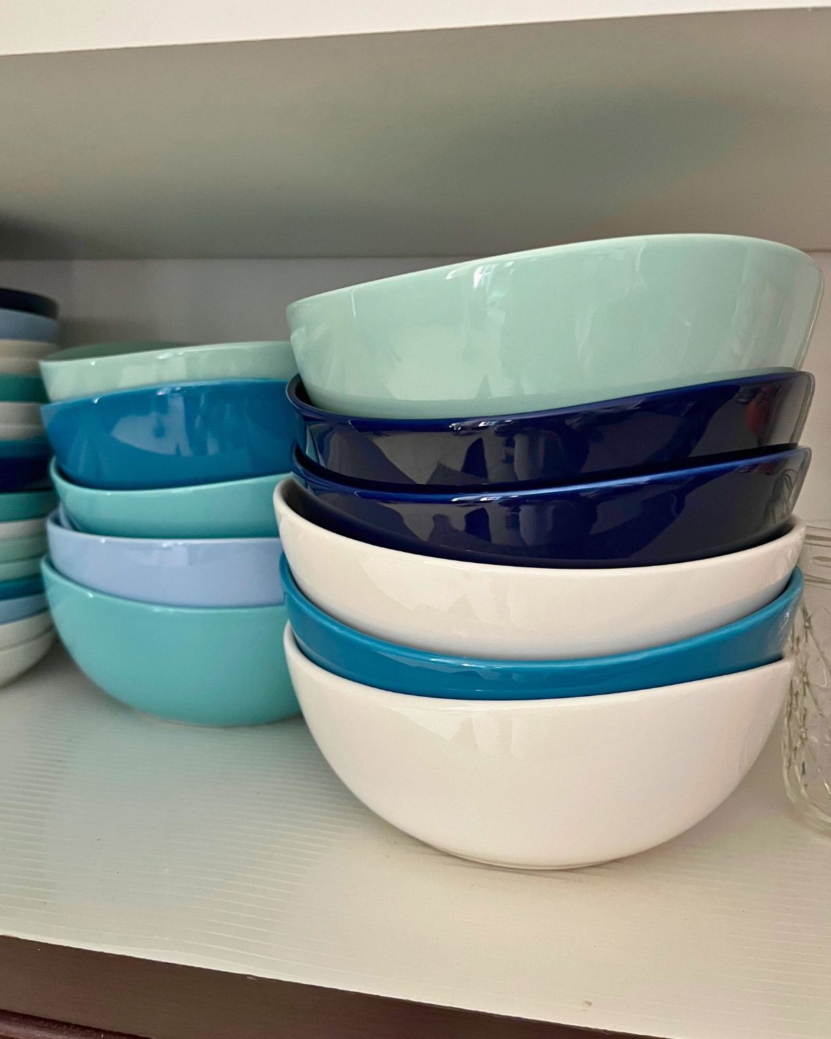 stacks of blue and white soup bowls in cabinet.