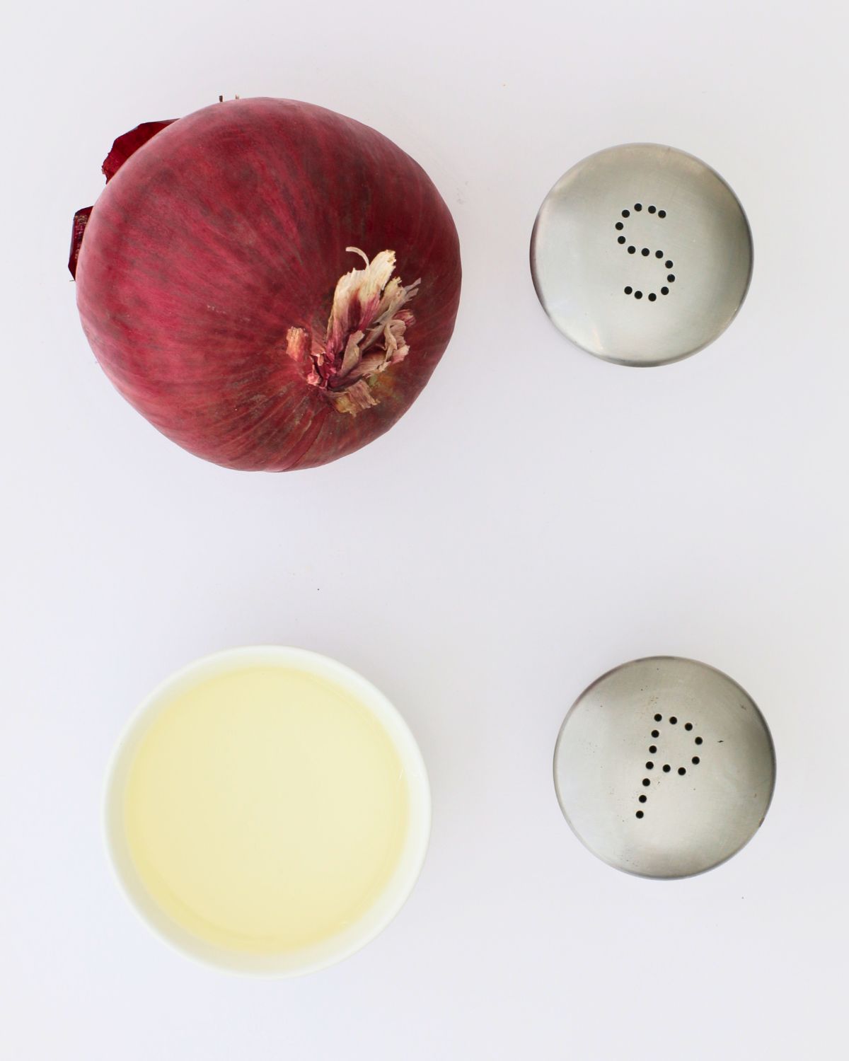 onion, vinegar, salt, and pepper on white table.