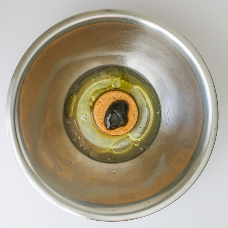 sugar, oil, water, and vanilla bean paste added to bowl.